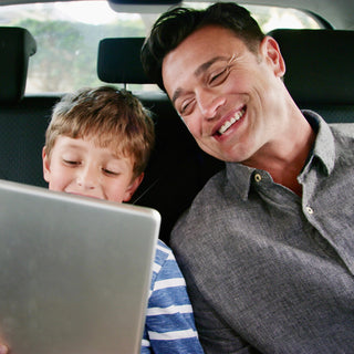 Hispanic Dad and Son with iPad in the car